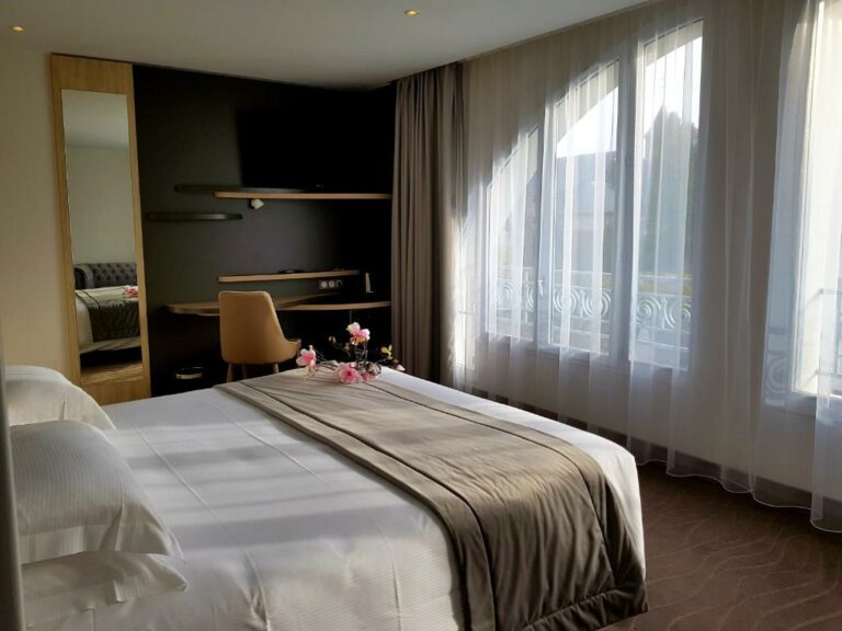 Una o más camas en alojamiento en el Brit Hotel de Grignan Vichy