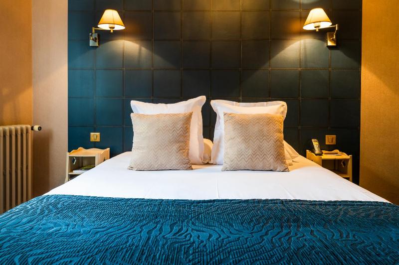 Un ou plusieurs lits dans un hébergement de l'établissement Hôtel le Cheval Blanc
